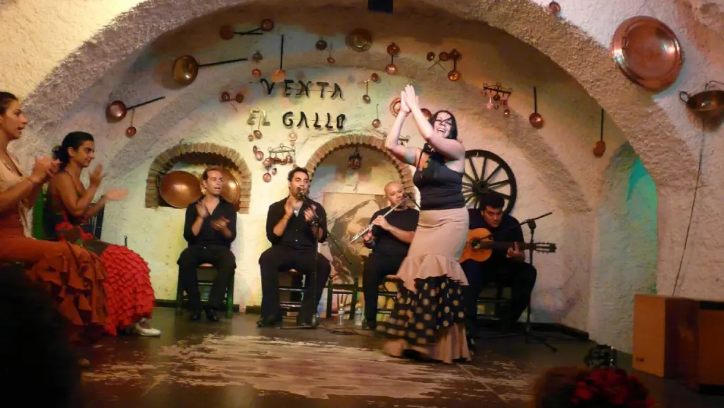 A woman performing and a group of musicians play instruments in the background