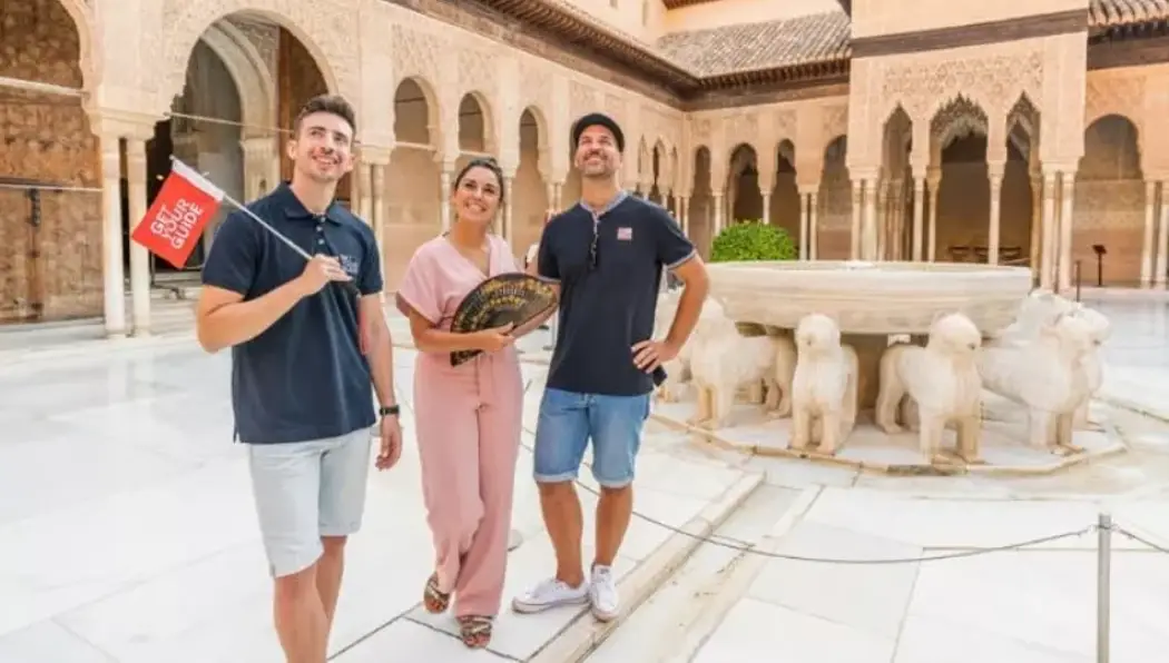 A guide explaining the Nasrid Palaces to the tourists