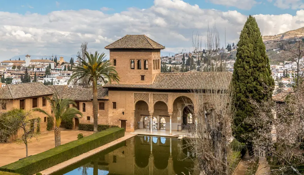 Partal Courtyard surrounded by trees and a pool in front of it