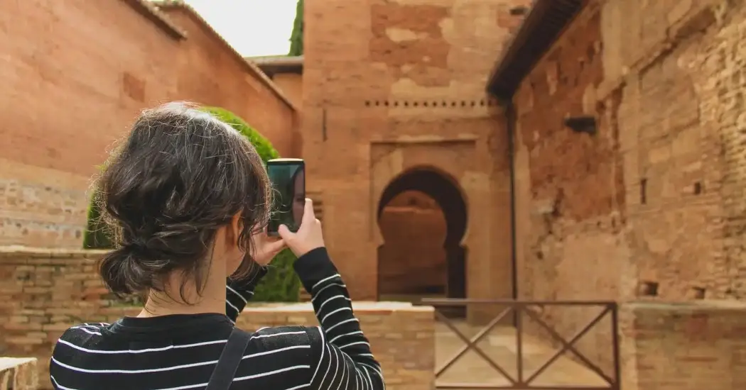 A tourist capturing a picture of the stunning Alhambra Palace